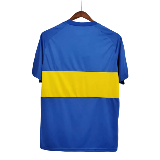 https://cdn.shopify.com/s/files/1/0826/7228/8075/files/19811982-boca-juniors-home-retro-jersey-351287.webp?v=1741197156