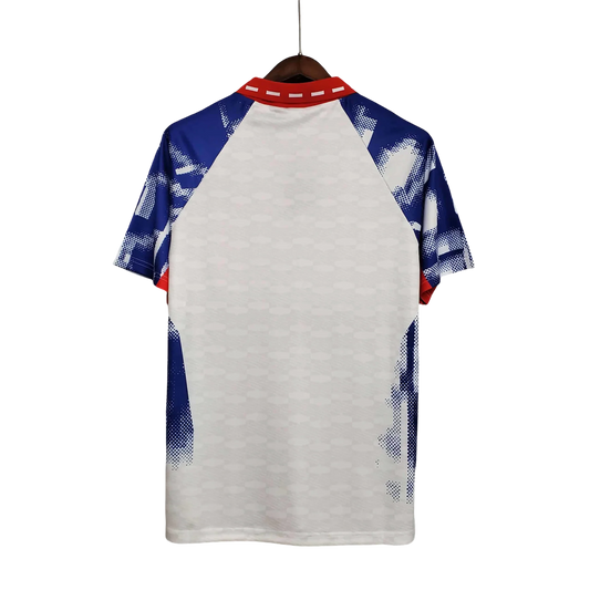https://cdn.shopify.com/s/files/1/0826/7228/8075/files/19931994-paris-saint-germain-commodore-away-white-retro-756711.webp?v=1741199393