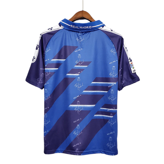 https://cdn.shopify.com/s/files/1/0826/7228/8075/files/19941996-real-madrid-teka-blue-away-retro-kit-classickits433-416774.webp?v=1741199039