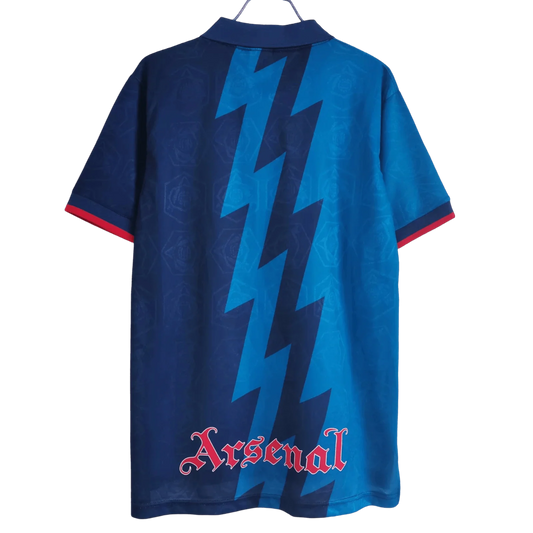 https://cdn.shopify.com/s/files/1/0826/7228/8075/files/19951996-arsenal-jvc-blue-away-retro-kit-classickits433-853342.webp?v=1741199334