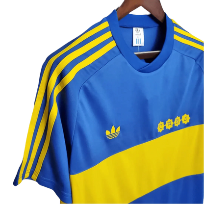 https://cdn.shopify.com/s/files/1/0826/7228/8075/files/19811982-boca-juniors-home-retro-jersey-345915.webp?v=1741197157