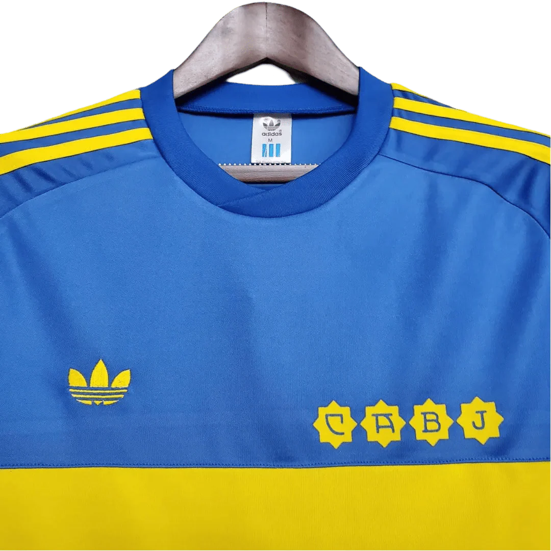 https://cdn.shopify.com/s/files/1/0826/7228/8075/files/19811982-boca-juniors-home-retro-jersey-609090.webp?v=1741197158