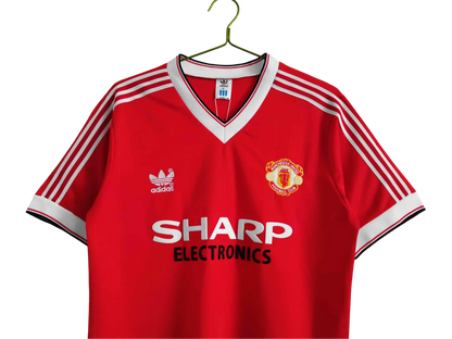 https://cdn.shopify.com/s/files/1/0826/7228/8075/files/1983-manchester-united-sharp-electronics-home-retro-kit-short-sleeves-classickits433-378751.webp?v=1741197622