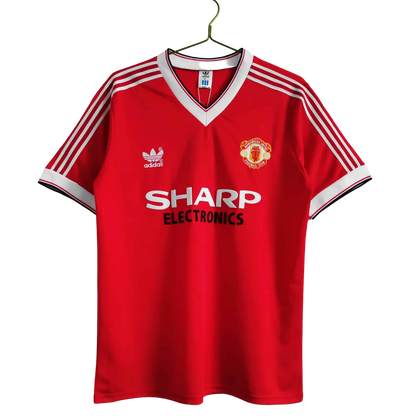 https://cdn.shopify.com/s/files/1/0826/7228/8075/files/1983-manchester-united-sharp-electronics-home-retro-kit-short-sleeves-classickits433-527905.webp?v=1741197621