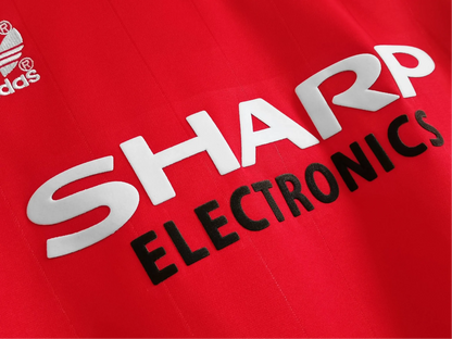 https://cdn.shopify.com/s/files/1/0826/7228/8075/files/1983-manchester-united-sharp-electronics-home-retro-kit-short-sleeves-classickits433-665109.webp?v=1741197621