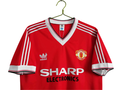https://cdn.shopify.com/s/files/1/0826/7228/8075/files/1983-manchester-united-sharp-electronics-home-retro-kit-short-sleeves-classickits433-952908.webp?v=1741197620