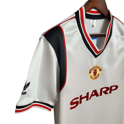 https://cdn.shopify.com/s/files/1/0826/7228/8075/files/19851986-manchester-united-sahrp-white-away-retro-kit-classickits433-401204.webp?v=1741199168