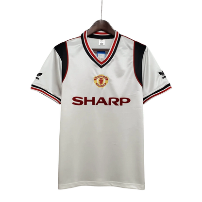 https://cdn.shopify.com/s/files/1/0826/7228/8075/files/19851986-manchester-united-sahrp-white-away-retro-kit-classickits433-441854.webp?v=1741199169