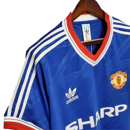 https://cdn.shopify.com/s/files/1/0826/7228/8075/files/19861988-manchester-united-sharp-away-retro-kit-classickits433-480559.webp?v=1741197674