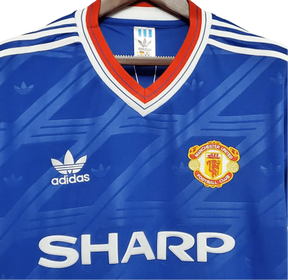 https://cdn.shopify.com/s/files/1/0826/7228/8075/files/19861988-manchester-united-sharp-blue-third-retro-kit-classickits433-452688.webp?v=1741199164