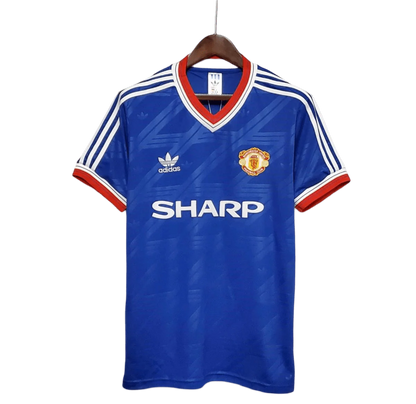 https://cdn.shopify.com/s/files/1/0826/7228/8075/files/19861988-manchester-united-sharp-blue-third-retro-kit-classickits433-660766.webp?v=1741199165