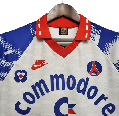 https://cdn.shopify.com/s/files/1/0826/7228/8075/files/19931994-paris-saint-germain-commodore-away-white-retro-502544.webp?v=1741199394
