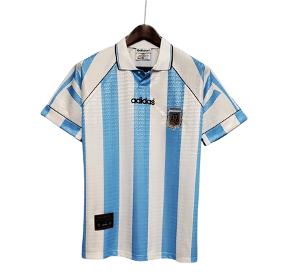 https://cdn.shopify.com/s/files/1/0826/7228/8075/files/19941996-argentina-home-retro-jersey-915760.webp?v=1741198527