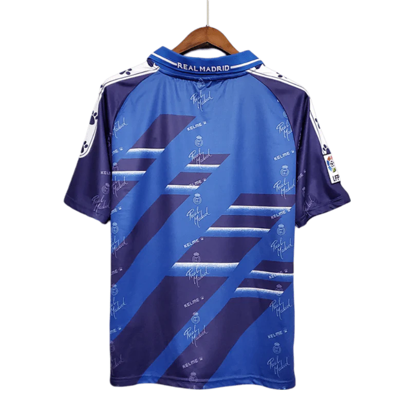 https://cdn.shopify.com/s/files/1/0826/7228/8075/files/19941996-real-madrid-teka-blue-away-retro-kit-classickits433-416774.webp?v=1741199039