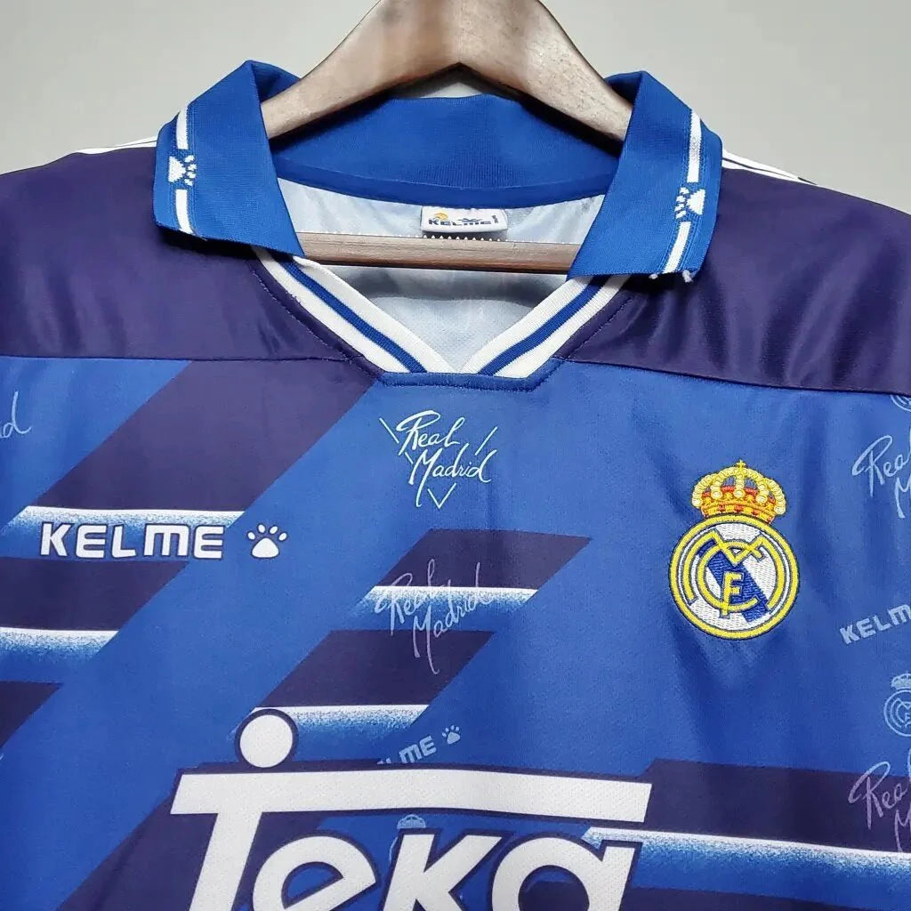 https://cdn.shopify.com/s/files/1/0826/7228/8075/files/19941996-real-madrid-teka-blue-away-retro-kit-classickits433-482271.webp?v=1741199039