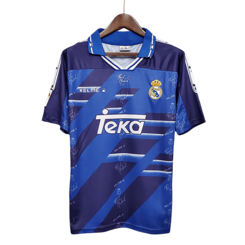 https://cdn.shopify.com/s/files/1/0826/7228/8075/files/19941996-real-madrid-teka-blue-away-retro-kit-classickits433-610051.webp?v=1741199040
