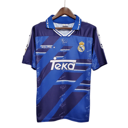 https://cdn.shopify.com/s/files/1/0826/7228/8075/files/19941996-real-madrid-teka-blue-away-retro-kit-classickits433-610051.webp?v=1741199040