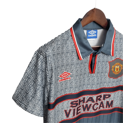 https://cdn.shopify.com/s/files/1/0826/7228/8075/files/19951996-manchester-united-sahrp-viewcam-gray-away-retro-kit-classickits433-611103.webp?v=1741199198