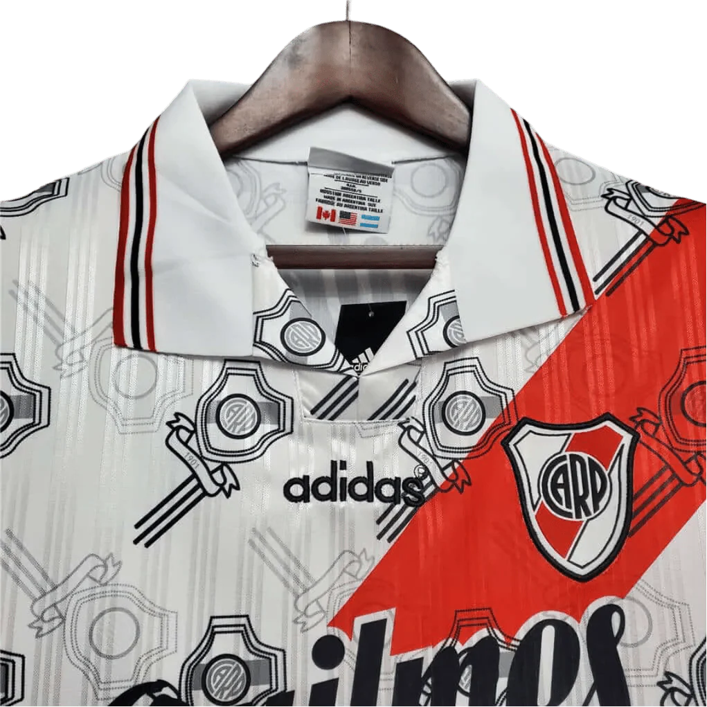 https://cdn.shopify.com/s/files/1/0826/7228/8075/files/19951996-river-plate-quilmes-home-retro-jersey-293865.webp?v=1741197180