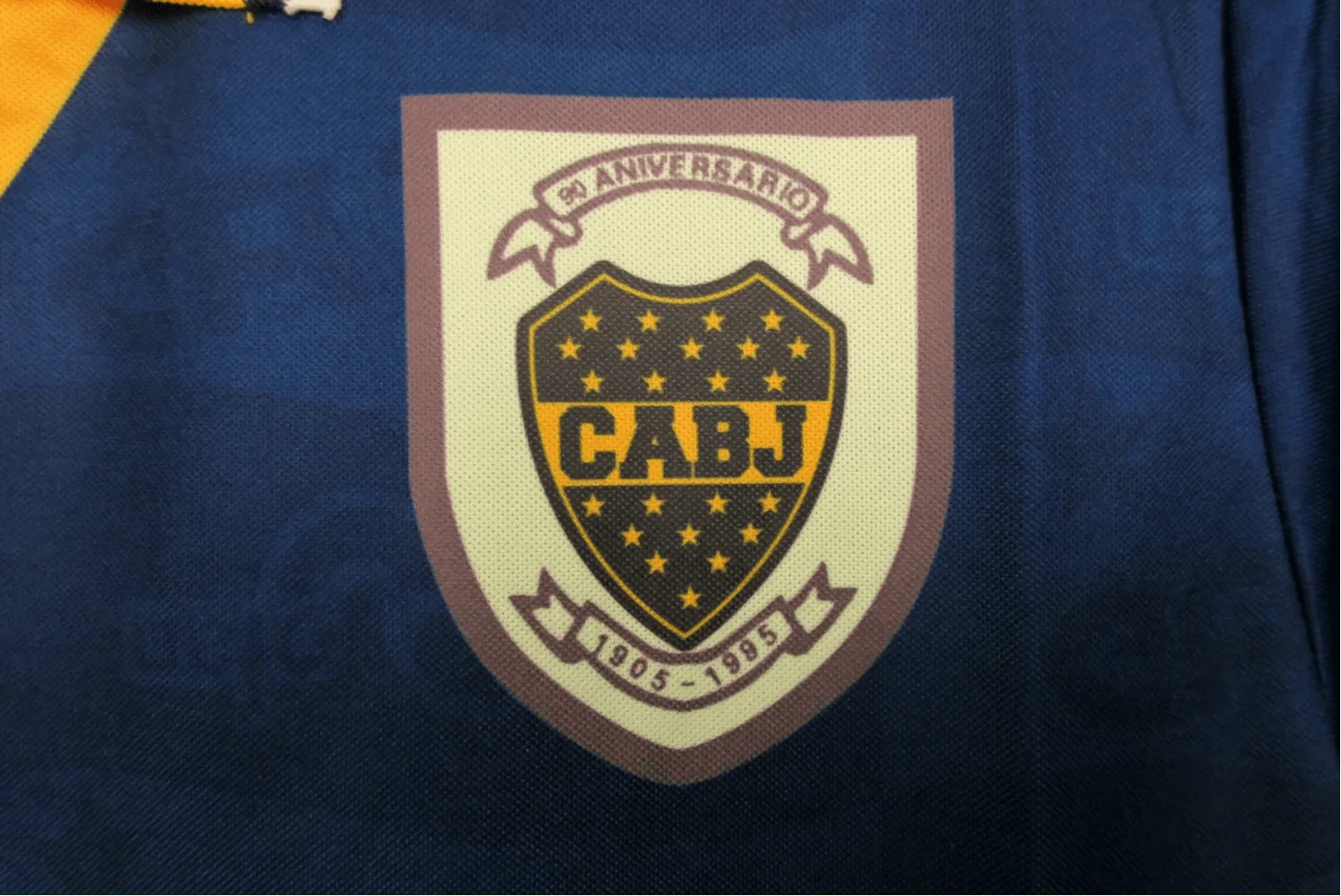 https://cdn.shopify.com/s/files/1/0826/7228/8075/files/19951997-boca-juniors-quilmes-home-retro-jersey-339154.webp?v=1741197187