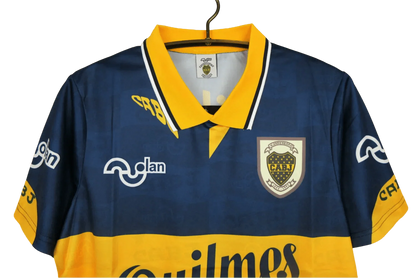 https://cdn.shopify.com/s/files/1/0826/7228/8075/files/19951997-boca-juniors-quilmes-home-retro-jersey-760166.webp?v=1741197187