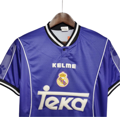 https://cdn.shopify.com/s/files/1/0826/7228/8075/files/19971998-real-madrid-teka-blue-away-retro-kit-classickits433-501073.webp?v=1741199032