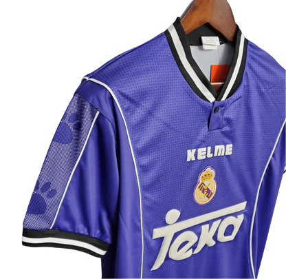 https://cdn.shopify.com/s/files/1/0826/7228/8075/files/19971998-real-madrid-teka-blue-away-retro-kit-classickits433-939461.webp?v=1741199033