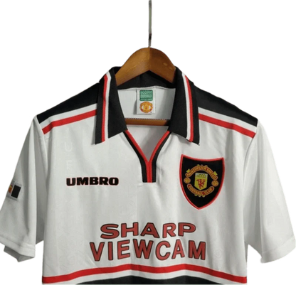 https://cdn.shopify.com/s/files/1/0826/7228/8075/files/19971999-manchester-united-sharp-viewcam-white-away-retro-kit-classickits433-415120.webp?v=1741199144
