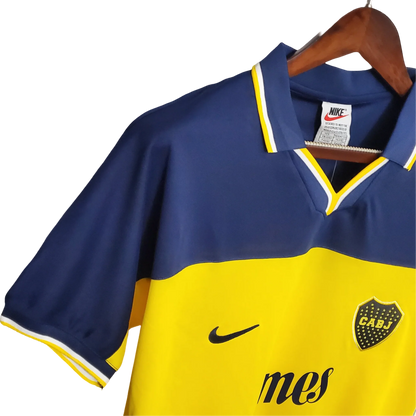 https://cdn.shopify.com/s/files/1/0826/7228/8075/files/19981999-boca-juniors-quilmes-home-retro-jersey-372575.webp?v=1741197210