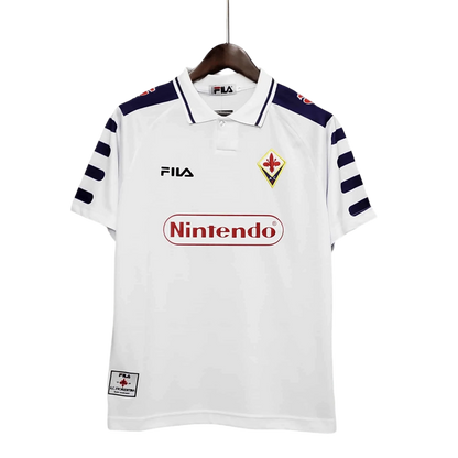 https://cdn.shopify.com/s/files/1/0826/7228/8075/files/19981999-fiorentina-florence-nintendo-fila-away-retro-kit-classickits433-772787.webp?v=1741199024