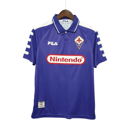 https://cdn.shopify.com/s/files/1/0826/7228/8075/files/19981999-fiorentina-florence-nintendo-fila-home-retro-kit-classickits433-113138.webp?v=1741199046