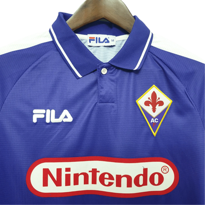 https://cdn.shopify.com/s/files/1/0826/7228/8075/files/19981999-fiorentina-florence-nintendo-fila-home-retro-kit-classickits433-619112.webp?v=1741199046