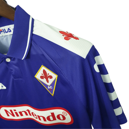https://cdn.shopify.com/s/files/1/0826/7228/8075/files/19981999-fiorentina-florence-nintendo-fila-home-retro-kit-classickits433-990051.webp?v=1741199047