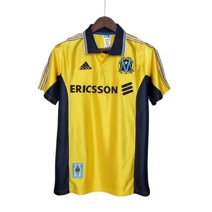 https://cdn.shopify.com/s/files/1/0826/7228/8075/files/19981999-olympique-de-marseille-ericsson-away-retro-jersey-387343.webp?v=1741199398