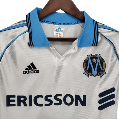 https://cdn.shopify.com/s/files/1/0826/7228/8075/files/19981999-olympique-de-marseille-ericsson-home-retro-jersey-210450.webp?v=1741199413