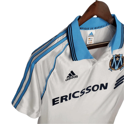 https://cdn.shopify.com/s/files/1/0826/7228/8075/files/19981999-olympique-de-marseille-ericsson-home-retro-jersey-732281.webp?v=1741199415