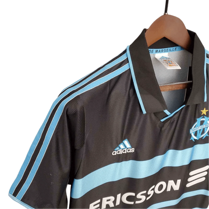 https://cdn.shopify.com/s/files/1/0826/7228/8075/files/19992000-olympique-de-marseille-ericsson-home-retro-kit-classickits433-609441.webp?v=1741199402