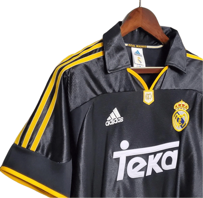 https://cdn.shopify.com/s/files/1/0826/7228/8075/files/19992000-real-madrid-teka-black-away-retro-kit-classickits433-464064.webp?v=1741199019