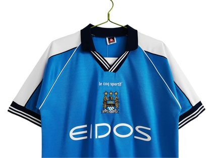 https://cdn.shopify.com/s/files/1/0826/7228/8075/files/19992001-manchester-city-eidos-home-retro-kit-classickits433-162597.webp?v=1741199201