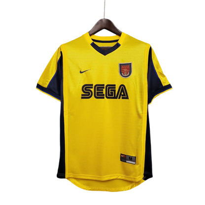 https://cdn.shopify.com/s/files/1/0826/7228/8075/files/20002001-arsenal-sega-yellow-away-retro-kit-classickits433-271552.webp?v=1741199340