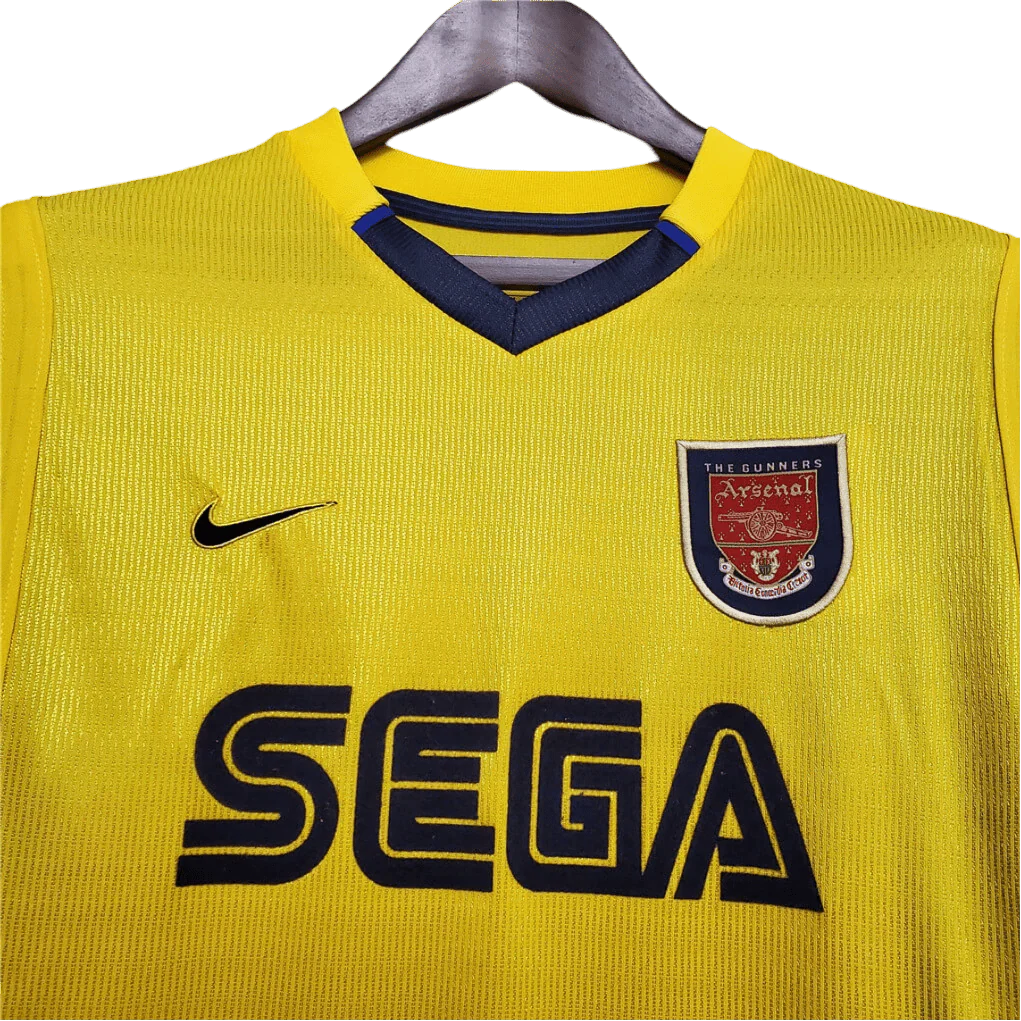 https://cdn.shopify.com/s/files/1/0826/7228/8075/files/20002001-arsenal-sega-yellow-away-retro-kit-classickits433-549148.webp?v=1741199341