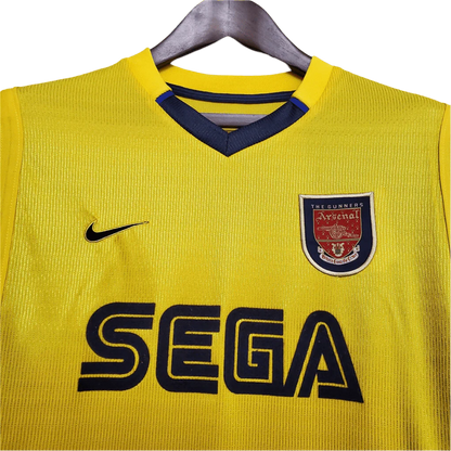 https://cdn.shopify.com/s/files/1/0826/7228/8075/files/20002001-arsenal-sega-yellow-away-retro-kit-classickits433-549148.webp?v=1741199341