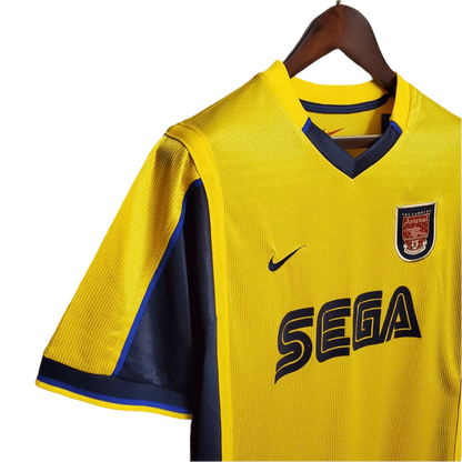 https://cdn.shopify.com/s/files/1/0826/7228/8075/files/20002001-arsenal-sega-yellow-away-retro-kit-classickits433-699228.webp?v=1741199339