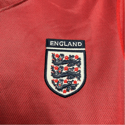 https://cdn.shopify.com/s/files/1/0826/7228/8075/files/2002-england-away-red-retro-kit-680902.webp?v=1741196954