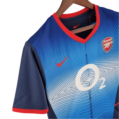 https://cdn.shopify.com/s/files/1/0826/7228/8075/files/20022004-arsenal-sponsor-o2-blue-away-retro-kit-classickits433-641706.webp?v=1741199338