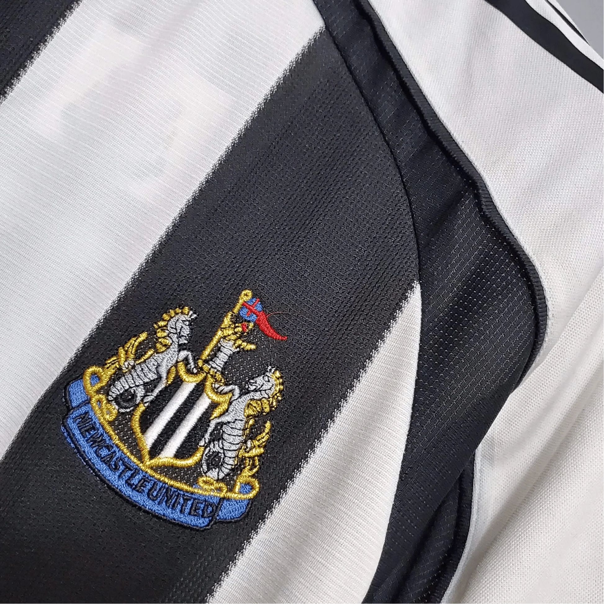 https://cdn.shopify.com/s/files/1/0826/7228/8075/files/20052006-newcastle-utd-northern-rock-home-retro-kit-classickits433-114101.webp?v=1741197850