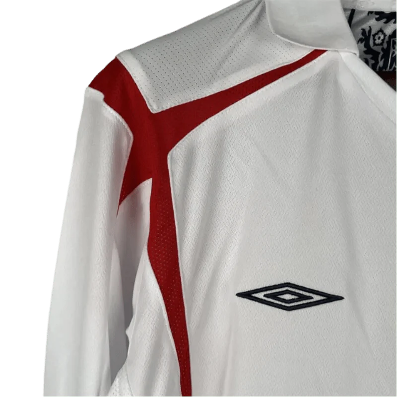 https://cdn.shopify.com/s/files/1/0826/7228/8075/files/2006-england-home-retro-kit-long-sleeves-184439.webp?v=1741196948