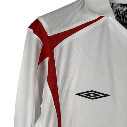 https://cdn.shopify.com/s/files/1/0826/7228/8075/files/2006-england-home-retro-kit-long-sleeves-184439.webp?v=1741196948