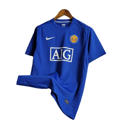 https://cdn.shopify.com/s/files/1/0826/7228/8075/files/20082009-manchester-united-aig-blue-third-retro-kit-classickits433-411169.webp?v=1741198443