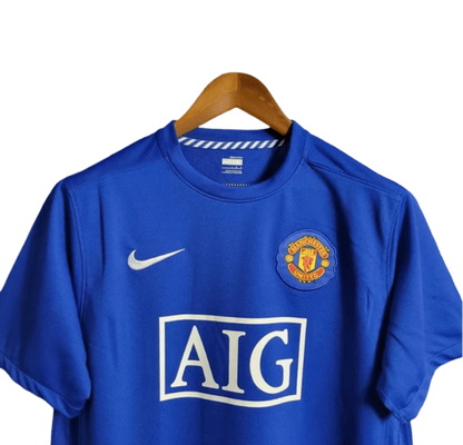 https://cdn.shopify.com/s/files/1/0826/7228/8075/files/20082009-manchester-united-aig-blue-third-retro-kit-classickits433-615669.webp?v=1741198442